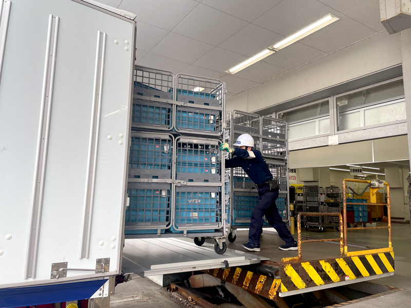 郵便輸送の作業。荷物をトラックに積み込むところ