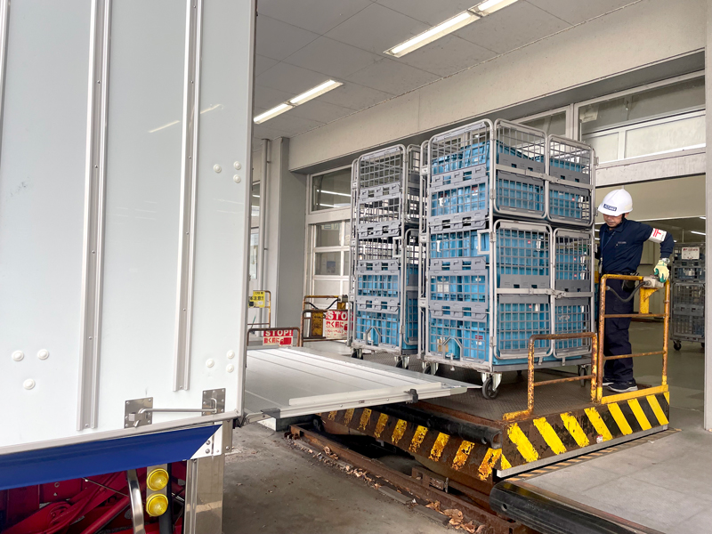 郵便輸送の作業。荷物をトラックに積み込むところ